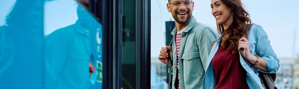 Happy couple getting on charter bus